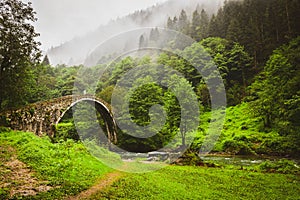 Female tourist walk on old ottoman empire bridge in Ayder , Turkey. Firtina Creek travel points of interest