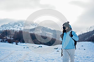 Female tourist wearing a protective mask in nature on mountain holiday vacation.Active vacation during the pandemic.Natural beauty