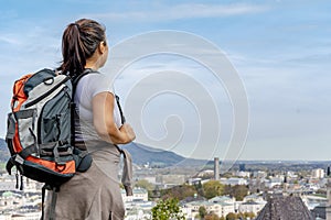 A female tourist 40-45 years old with a backpack on her shoulders against the backdrop of a mountain landscape, ancient architectu photo