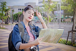 Female tourists Looking for destinations on the map in the town