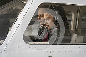 Female Trainee Pilot and Flight Instructor in an Aircraft Cockpit