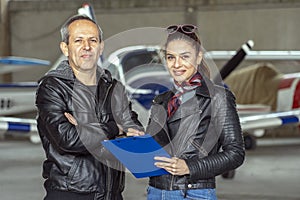 Smiling Woman and Man Pilots in a Hangar photo