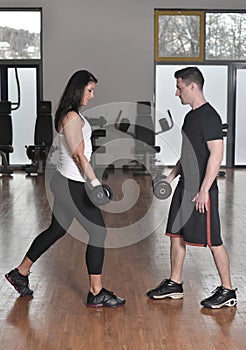 Female trainer working with her trainee with weights