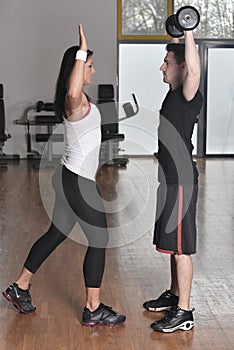 Female trainer working with her trainee with weights