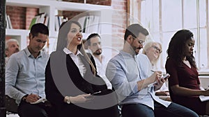 Female training participant raise hand up ask question at conference