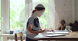 Female translator translates text working sit at table at home