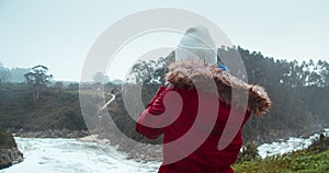 Female travel photographer shoot stormy beach day of bad weather and big waves