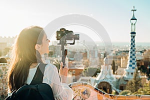 Female travel photographer/videographer and bloger using camera with gimbal stabiliser crane in Barcelona,Spain.Travel photography photo