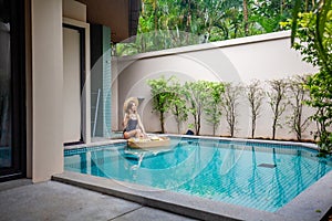 Female traveler enjoying a delicious floating breakfast in a modern tropical villa