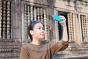 Female traveler selfie with her smartphone in angkor wat cambodia