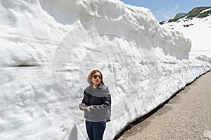 Female traveler and snow wall at japan alps tateyama kurobe alpine route