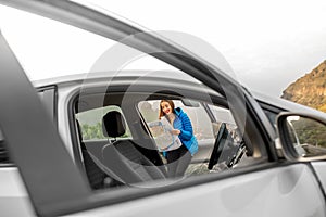 Female traveler with toursit map near the car