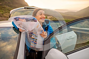 Female traveler with toursit map near the car