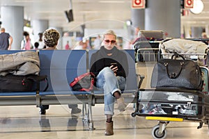 Female traveler using cell phone while waiting.