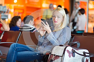 Female traveler using cell phone while waiting.