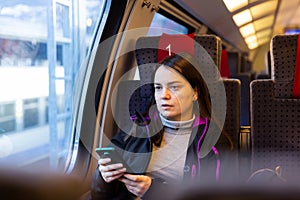 Female traveler using mobile phone while riding train