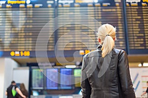 Female traveller checking flight departures board.