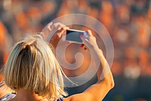 Female traveller make a photo of Dubrovnik to the phone.