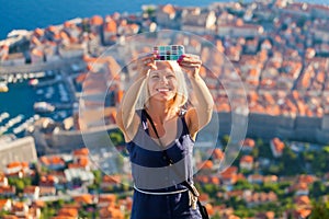 Female traveller make a selfy photo to the phone.