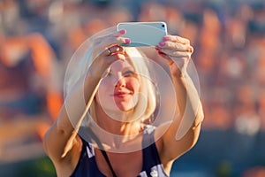 Female traveller make a selfy photo to the phone.