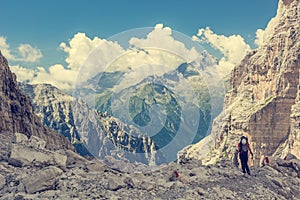 Female trekker walking along mountain valley.