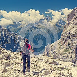 Female trekker walking along mountain valley.