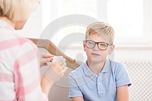 Female tutor asking her pupil to translate word, writed on card. Young boy trying to remeber translation. They are photo