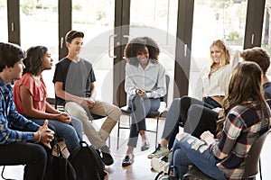 Female Tutor Leading Discussion Group Amongst High School Pupils