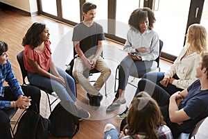 Female Tutor Leading Discussion Group Amongst High School Pupils