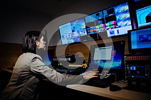 Female TV director control editing room in television studio.Operating vision mixer console equipment in a broadcast panel gallery photo