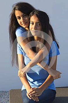 Female twins embrace each other