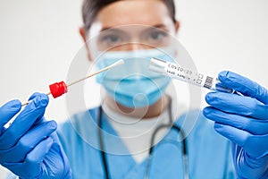 Female UK GP physician wearing personal protective equipment performing Coronavirus COVID-19 rt-PCR test photo