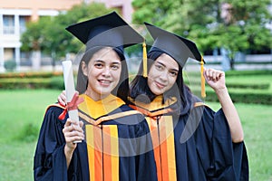Female university graduates celebrate graduation with happiness after receive degree certificate in commencement ceremony. Asian