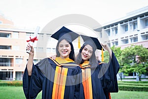 Female university graduates celebrate graduation with happiness after receive degree certificate in commencement ceremony. Asian