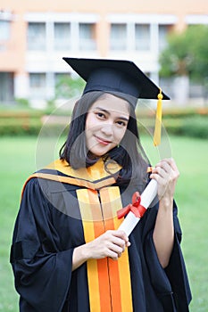 Female university graduates celebrate graduation with happiness after receive degree certificate in commencement ceremony. Asian