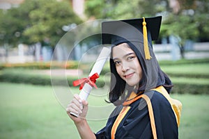 Female university graduates celebrate graduation with happiness after receive degree certificate in commencement ceremony. Asian