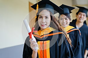 Female university graduates celebrate happily after completed and received diploma degree certificate in commencement ceremony. Th