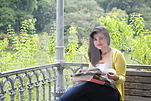 Una mujer universidad alumno libros a archivos sobre el cli en el parque 