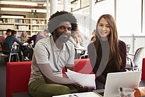 Female University Student Working In Library With Tutor