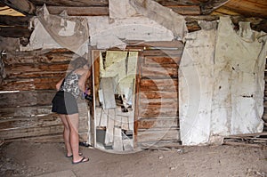 Female urban explorer investigates an abandoned building interior in Miners Delight Wyoming