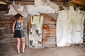 Female urban explorer investigates an abandoned building interior in Miners Delight Wyoming