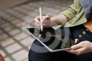 A female using a digital tablet touchpad, using stylus pen to design her graphic artwork