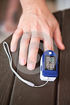 Female using oximeter for monitoring peripheral oxygen saturation, close up view