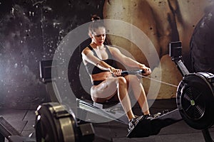 Female using rowing machine in gym. woman doing cardio workout in fitness club.