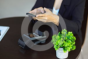 A female using smartphone to scan QR code on terminal machine