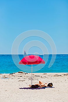 Female vacationers suntanning on sandy beach
