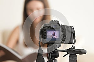 Female video blogger recording vlog on DSLR camera photo