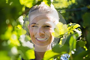 Female vintner standing in vineyard
