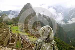 Female visitor wearing raincoat full of raindrops Looking at the Machu Picchu Inca citadel in light rain, Cusco, Peru