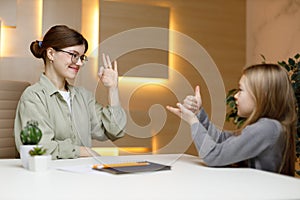 A female volunteer communicates with a deaf child using sign language